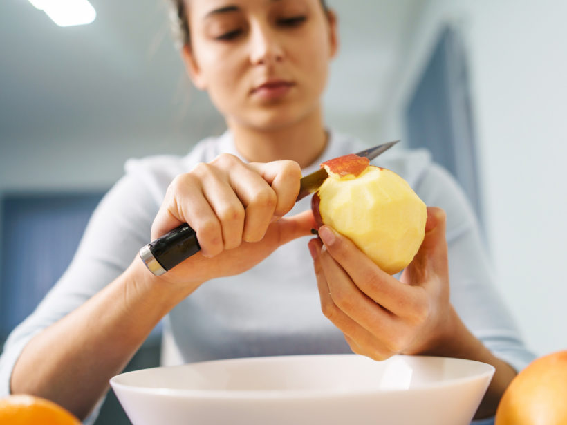 Eine Frau schält einen Apfel